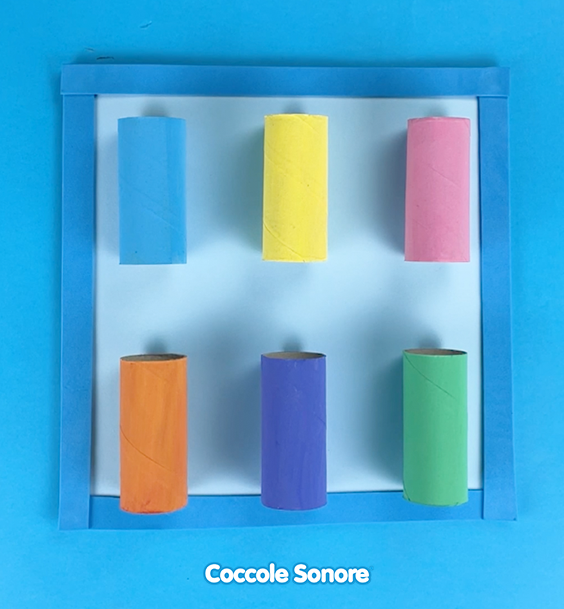 Ricaviamo un rettangolo di 30x30 cm, lo rivestiamo con il cartoncino e ci incolliamo sopra i nostri rotoli colorati. Noi lo abbiamo incorniciato con del feltro per poter avere una presa migliore, ma è facoltativo.