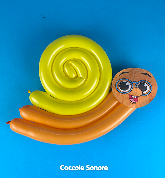 Gonfiamo il palloncino giallo e creiamo una chiocciola; gonfiamo il palloncino arancione e lo pieghiamo su se stesso per formare il corpo del lumachino. Infine incolliamo con il biadesivo il viso di Dado!